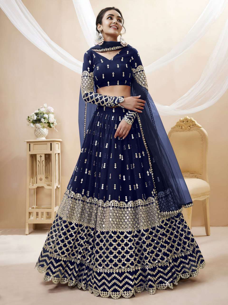  A graceful Royal Navy georgette lehenga adorned with Sequin...