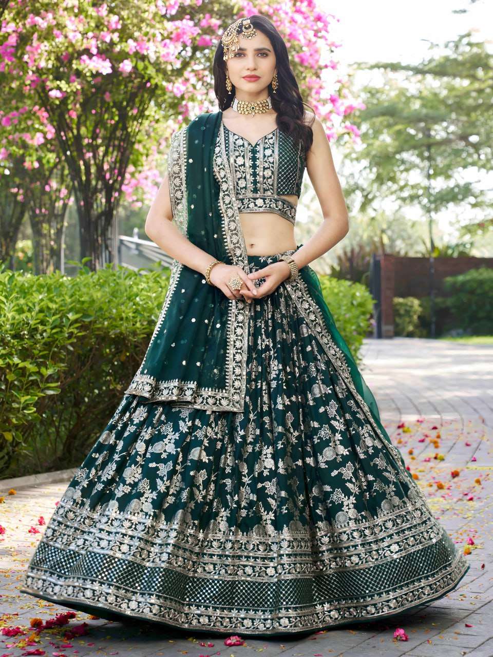 The flared lehenga is beautifully crafted in a rich green do...