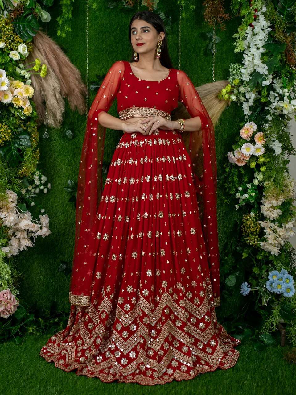 This vibrant red lehenga set showcases traditional sitara st...